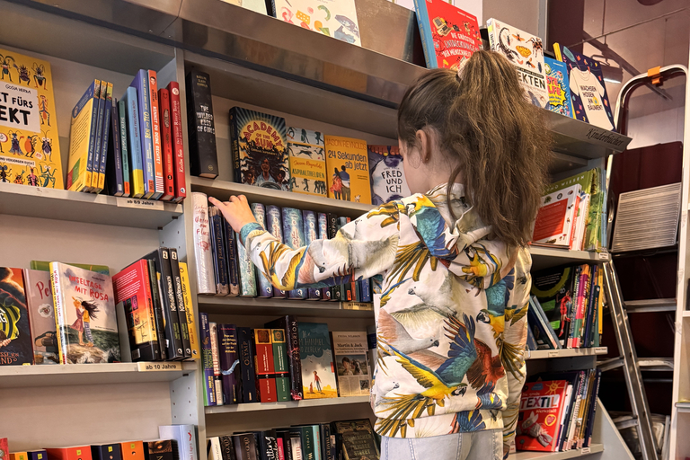 Zu sehen ist ein Kind vor einem Bücherregal.